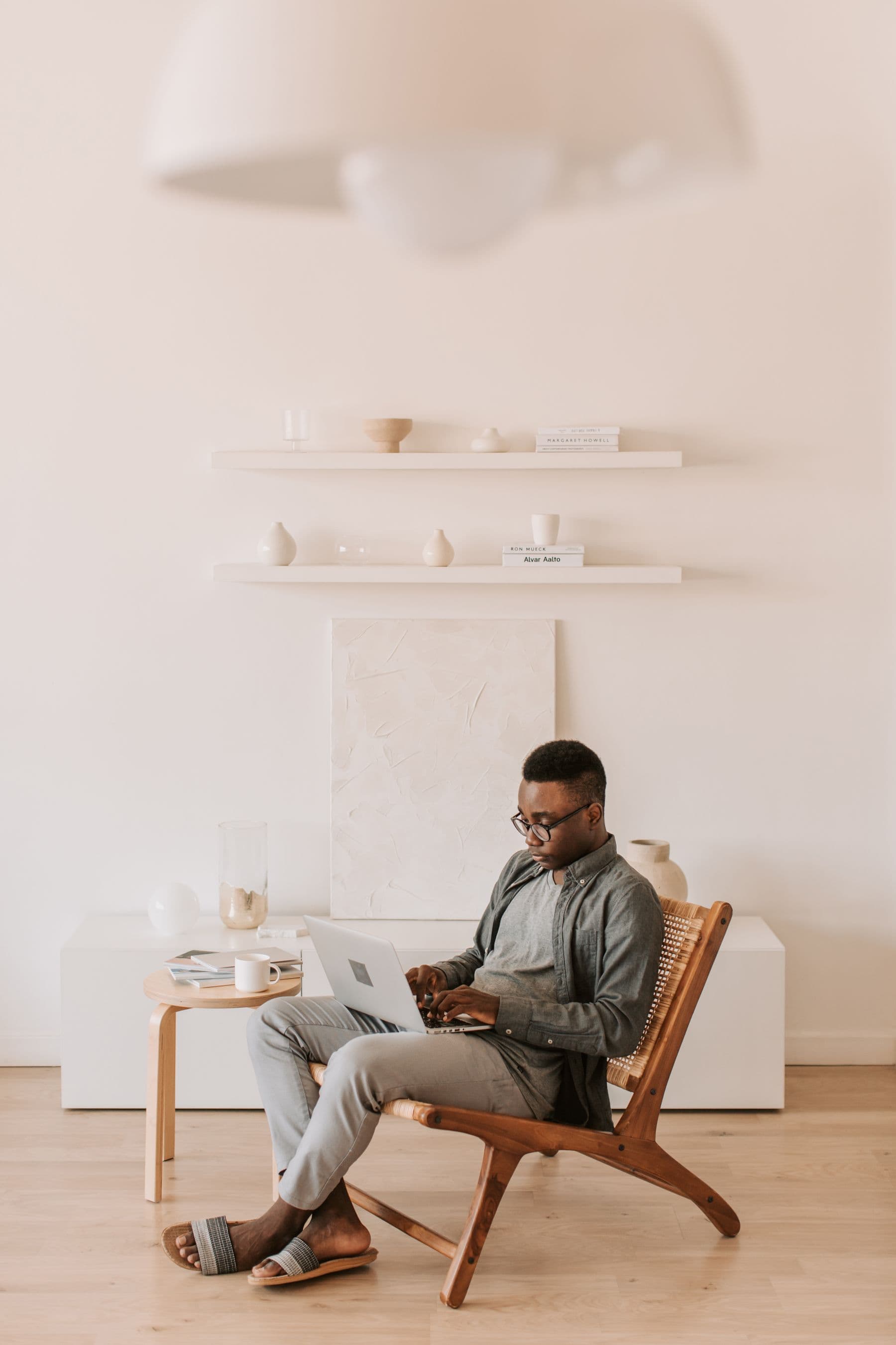 A man sitting with a laptop in a sunlit living room