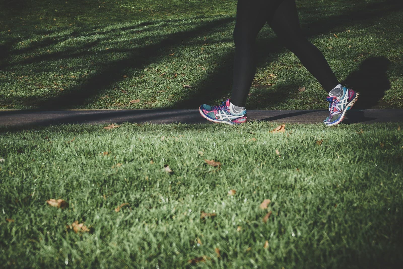 Running shoes on a sunlit park path