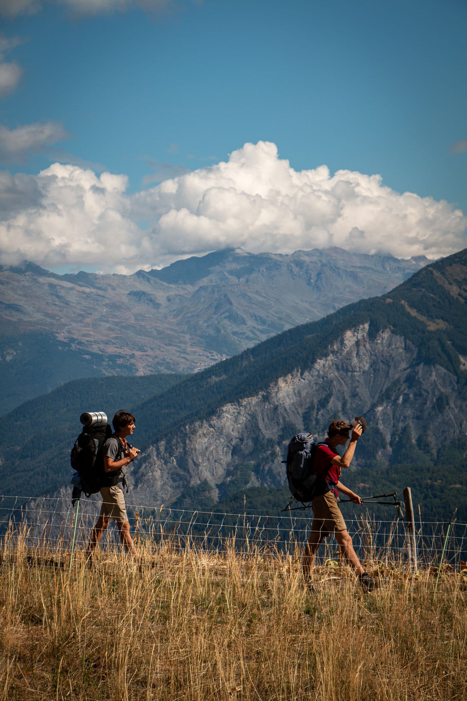 Two hikers walking through a mountain landscape